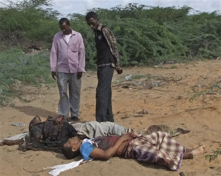 Local men view the body of Fazul Abdullah Mohammed, front right, and another unidentified man in Mogadishu, Somalia, after last week's shooting.